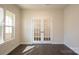Well-lit office space with French doors, hardwood floors, and a large window with blind at 10036 Paper Birch Dr, Charlotte, NC 28215