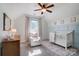 Bright bedroom with white crib, chair, ceiling fan, and ample natural light at 102 Leeper Ave, Belmont, NC 28012