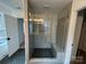 Elegant shower with glass door, a built-in seat, and herringbone tile design at 107 Spring View Ln, Statesville, NC 28677