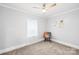 Bright bedroom featuring a ceiling fan, neutral walls, plush carpet, and a comfortable chair with decorative pillow at 1075 Wellman St, Gastonia, NC 28054