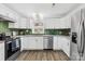 Stylish kitchen featuring white cabinets, stainless steel appliances, and green tile backsplash at 1075 Wellman St, Gastonia, NC 28054