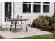 Cozy back patio featuring a dining set, garden beds, and access to the house at 14722 Tamarack Dr, Charlotte, NC 28278
