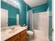Bright bathroom with teal walls, a single sink vanity, and a shower-tub combination at 17137 Red Feather Dr, Charlotte, NC 28277