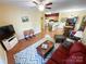 Living room with hardwood floors, a ceiling fan, and an open view to the dining and kitchen at 17137 Red Feather Dr, Charlotte, NC 28277