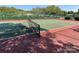 Community tennis court with net, fencing, and shade trees at 17137 Red Feather Dr, Charlotte, NC 28277