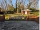Backyard features a brick outbuilding and a bench with brick and stone features overlooking a well-manicured lawn at 1807 Brantley Rd, Kannapolis, NC 28083