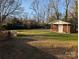 A building with a covered porch sits in a flat grassy back yard enclosed with a brick retaining wall at 1807 Brantley Rd, Kannapolis, NC 28083