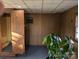 Well-lit basement with wood paneling, a plant, and a door to a bathroom with shower at 1807 Brantley Rd, Kannapolis, NC 28083