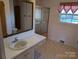 Bathroom featuring a tub/shower combo, mirrored cabinet, and vintage fixtures at 1807 Brantley Rd, Kannapolis, NC 28083