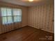 Cozy bedroom with patterned wallpaper, hardwood floors, and natural light from the windows at 1807 Brantley Rd, Kannapolis, NC 28083