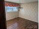 Dining room with hardwood floors, floral wallpaper, chandelier, and natural light from a window at 1807 Brantley Rd, Kannapolis, NC 28083