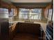 Classic kitchen with stainless appliances, wood cabinets, and natural light shining through sheer curtains at 1807 Brantley Rd, Kannapolis, NC 28083