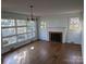 Bright living room with hardwood floors, a fireplace, and large windows overlooking the front yard at 1807 Brantley Rd, Kannapolis, NC 28083