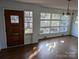 Bright living room with large windows, hardwood floors, and a classic chandelier fixture at 1807 Brantley Rd, Kannapolis, NC 28083