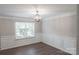 Formal dining room features hardwood floors, wainscotting, stylish light fixture, and large windows at 2043 Covered Bridge Ct, Rock Hill, SC 29732