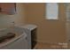 Bright laundry room featuring a washer, dryer, upper cabinet, and wire shelving at 2043 Covered Bridge Ct, Rock Hill, SC 29732