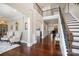 Inviting foyer with dark wood floors, grand staircase, columns and open view to the living room at 4131 Nottaway Place Dr, Matthews, NC 28105