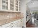 Kitchen featuring custom cabinets, granite countertops, and tiled backsplash with an easy transition into the dining area at 4131 Nottaway Place Dr, Matthews, NC 28105