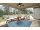 Inviting screened porch with comfortable seating, ceiling fan, and views of the backyard and playground at 4131 Nottaway Place Dr, Matthews, NC 28105