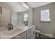 Bathroom featuring dual sinks, a large mirror, and a tub with shower; natural light through the window at 5104 Heathland Dr # 73, Charlotte, NC 28215