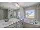 Bright bathroom with double sinks, a large mirror, a tub, and a separate glass shower at 5104 Heathland Dr # 73, Charlotte, NC 28215