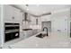Well-appointed kitchen features white cabinetry, a center island, stainless appliances and tile backsplash at 5104 Heathland Dr # 73, Charlotte, NC 28215