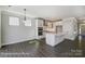 Open-concept kitchen featuring white cabinets, a large island, and stainless steel appliances at 5104 Heathland Dr # 73, Charlotte, NC 28215