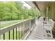 Long covered porch with white benches and black metal railings overlooking the front yard at 6108 Gold Creek Estate Dr, Hickory, NC 28601