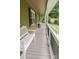 View of the long covered porch with white benches and black metal railings at 6108 Gold Creek Estate Dr, Hickory, NC 28601