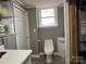 Bathroom featuring a toilet, sink with white cabinet, and window at 818 W 6Th St, Newton, NC 28658