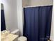 Neutral bathroom featuring a toilet, sink and shower/tub combo with blue curtain at 823 Prestwick Dr, Rock Hill, SC 29730