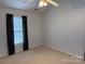 Neutral bedroom with ceiling fan and window with dark curtains at 823 Prestwick Dr, Rock Hill, SC 29730