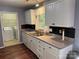 Modern kitchen featuring white cabinets, gray countertops and stainless steel sink, and views to laundry room at 823 Prestwick Dr, Rock Hill, SC 29730