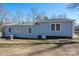 The backyard showcases a light blue home with an A/C unit and several white-framed windows at 939 Dameron Rd, Bessemer City, NC 28016