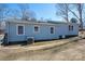 The backyard showcases a light blue home with an A/C unit and several white-framed windows at 939 Dameron Rd, Bessemer City, NC 28016