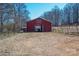 Exterior view of red barn surrounded by open field and trees at 939 Dameron Rd, Bessemer City, NC 28016