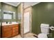 Bathroom with a single vanity, decorative mirror, stall shower, and a toilet for a practical layout at 939 Dameron Rd, Bessemer City, NC 28016