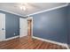 Bedroom with a white door leading to another room, hardwood floors, and blue walls at 939 Dameron Rd, Bessemer City, NC 28016