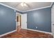 Bedroom with a white door leading to another room, hardwood floors, and light blue walls at 939 Dameron Rd, Bessemer City, NC 28016