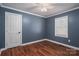 Bedroom with a white door and window, complemented by hardwood floors and blue walls at 939 Dameron Rd, Bessemer City, NC 28016