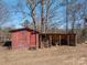 Red shed is shown with wood storage and open structure with grill and outdoor cooking space at 939 Dameron Rd, Bessemer City, NC 28016