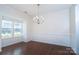 Bright dining room featuring hardwood floors, elegant chandelier lighting, and a large window at 9760 Springholm Dr, Charlotte, NC 28278