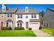 Charming two-story townhome with beige siding, attached garage, and well-manicured front lawn at 9760 Springholm Dr, Charlotte, NC 28278