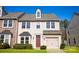 Charming two-story townhome with beige siding, attached garage, and well-maintained front lawn at 9760 Springholm Dr, Charlotte, NC 28278