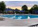 Community pool surrounded by lounge chairs and umbrellas at 9760 Springholm Dr, Charlotte, NC 28278
