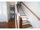 Staircase with hardwood treads and white risers leads to upper level at 9760 Springholm Dr, Charlotte, NC 28278
