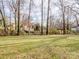 Large backyard with sparse dormant grass and scattered bare trees at 1005 Maywood St, Kannapolis, NC 28081