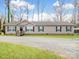 Ranch style home with gravel driveway, light siding, black shutters, and covered parking at 1005 Maywood St, Kannapolis, NC 28081