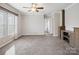 Spacious living room featuring a ceiling fan, large windows, plush carpet, and custom built-ins at 1005 Maywood St, Kannapolis, NC 28081