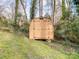 Wooden storage shed with double doors nestled in a wooded backyard at 1005 Maywood St, Kannapolis, NC 28081